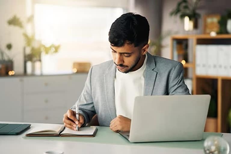 Indian student practicing real-world skills on laptop during online master degree program